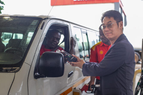Managing Director of Vivo Energy Ghana, Christian Li handing over a reusable bottle to a customer at Airport Shiell service station.