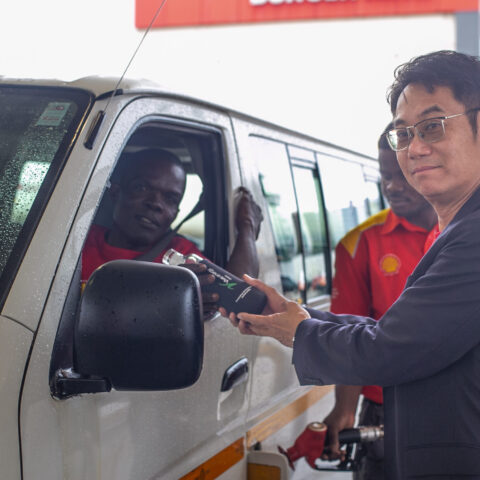 Managing Director of Vivo Energy Ghana, Christian Li handing over a reusable bottle to a customer at Airport Shiell service station.