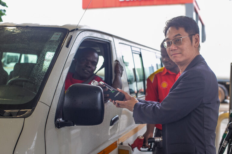 Managing Director of Vivo Energy Ghana, Christian Li handing over a reusable bottle to a customer at Airport Shiell service station.