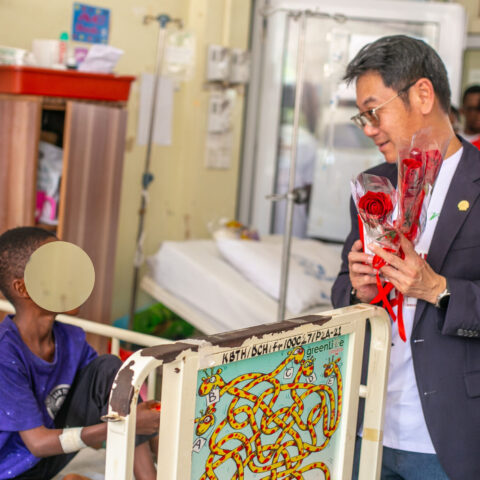 The Managing Director of Vivo Energy Ghana, Mr. Christian Li presenting chocolate and a rose flower to a patient in the children's ward.